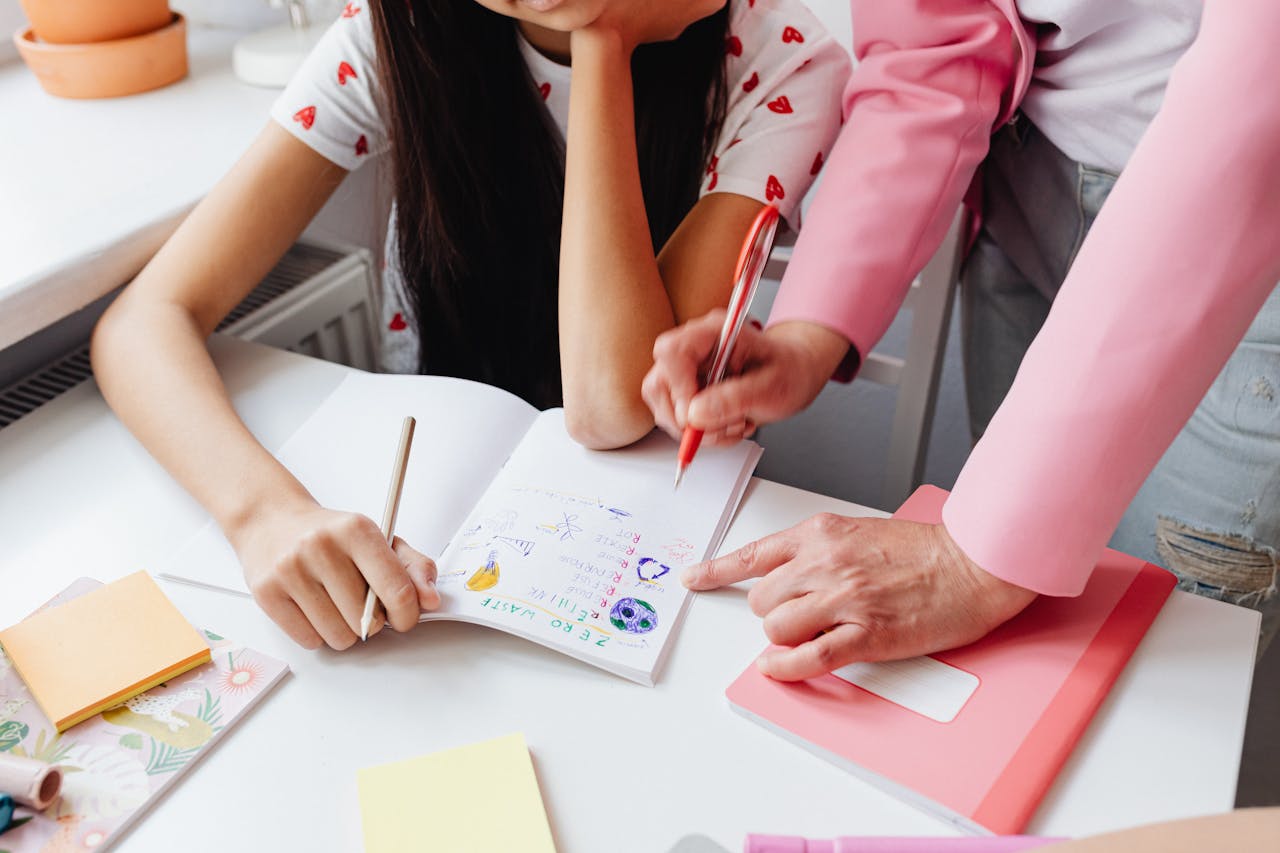 A child working on homework with assistance from an adult, focusing on learning and education.