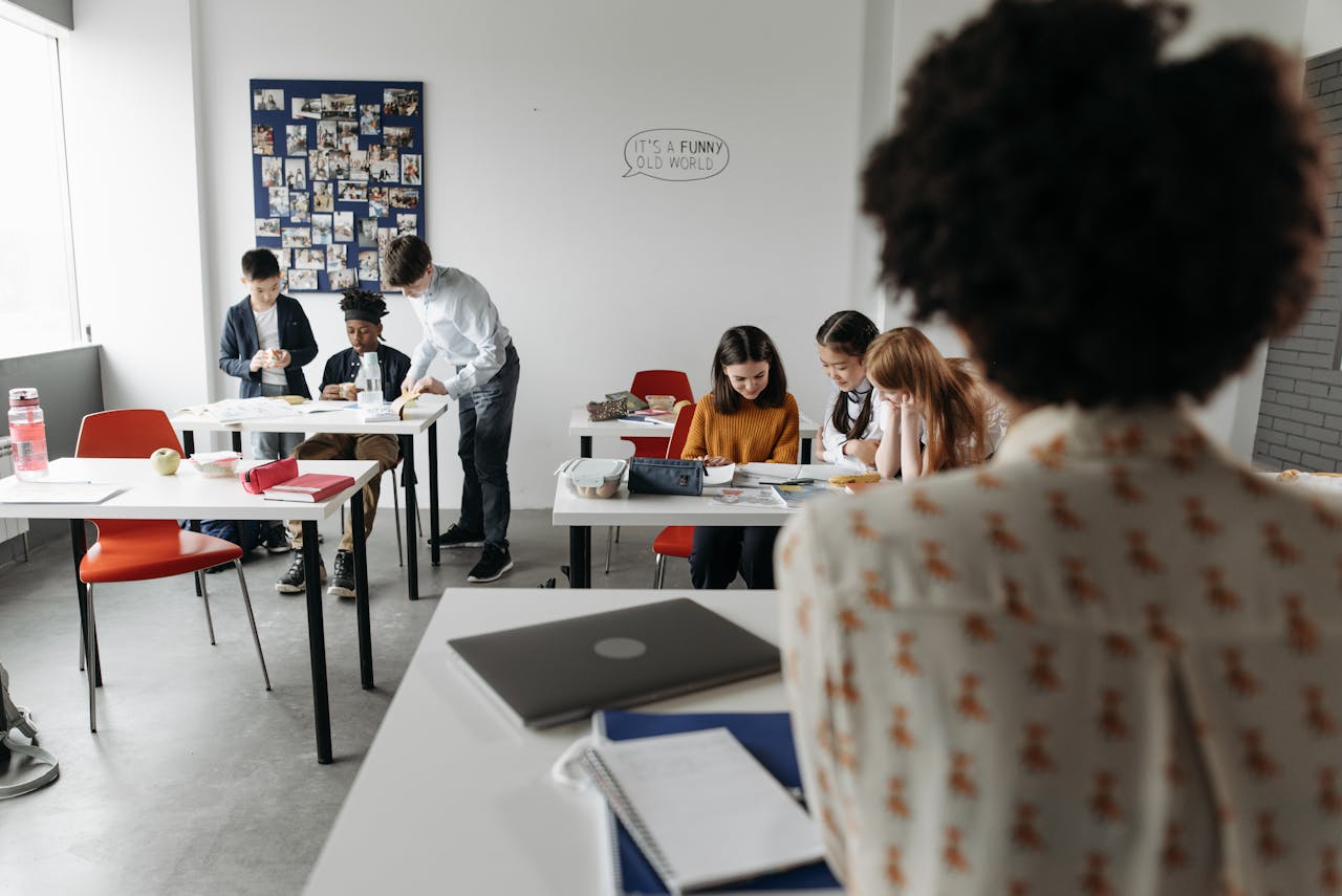 Students focused in a modern classroom with diverse activities and interactions.